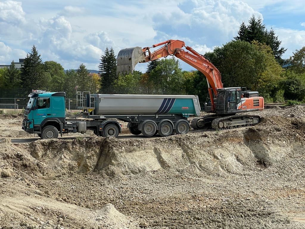 Bagger lädt belasteten Boden in einen LKW